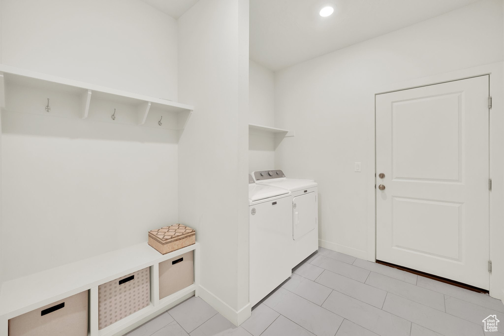 Laundry area with independent washer and dryer, baseboards, light tile patterned floors, and recessed lighting