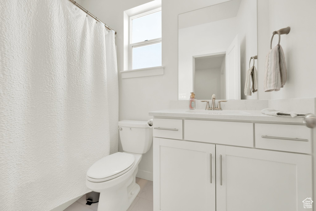 Bathroom featuring toilet, vanity, and tile patterned floors