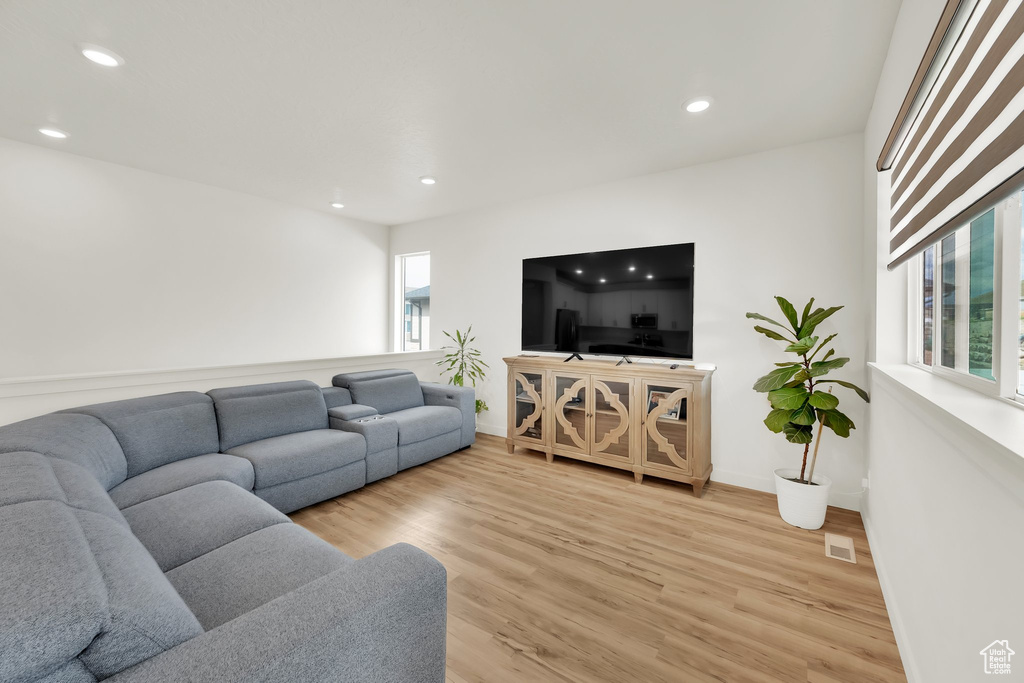 Living room with recessed lighting, light wood-style flooring, and baseboards