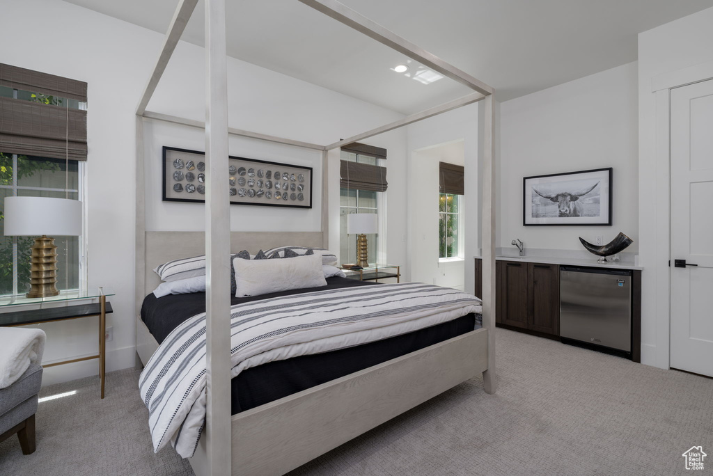 Carpeted bedroom with fridge