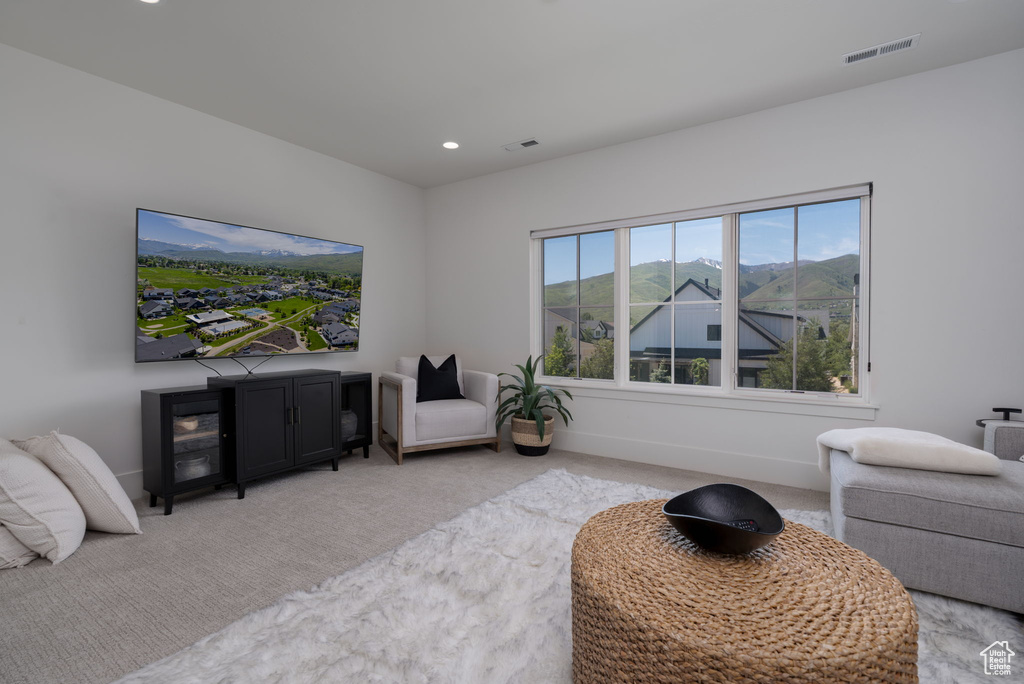 Living area featuring light colored carpet, recessed lighting, and baseboards