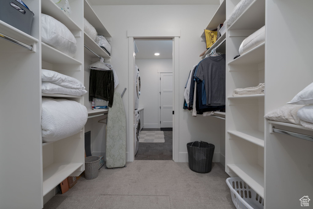 Walk in closet with estacked washer and dryer and carpet floors