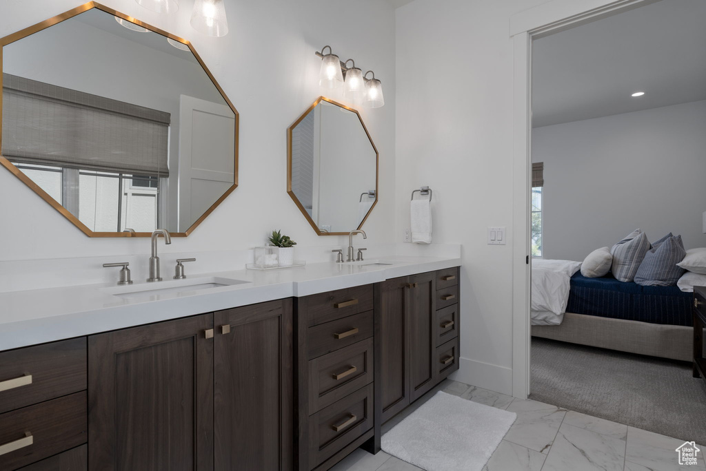 Ensuite bathroom with double vanity and marble finish flooring