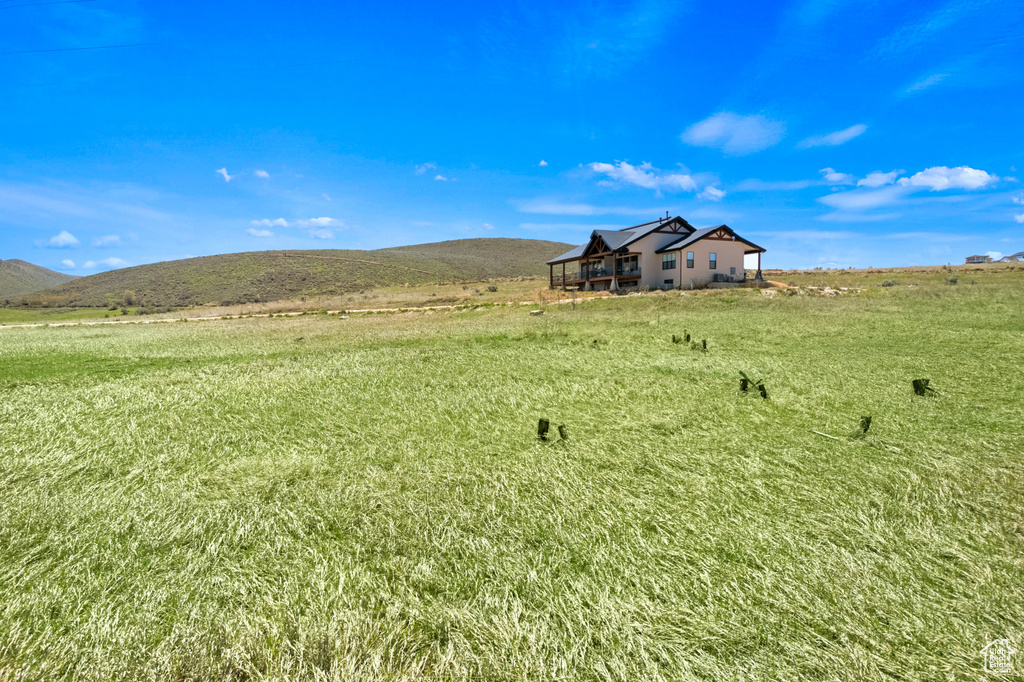 View of green lawn with a view of rural / pastoral area and a mountain view