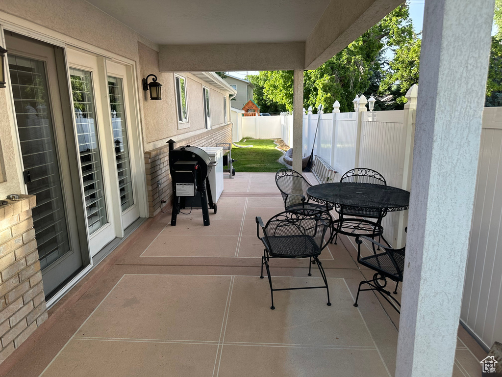 Fenced backyard featuring a grill, a patio, and outdoor dining space