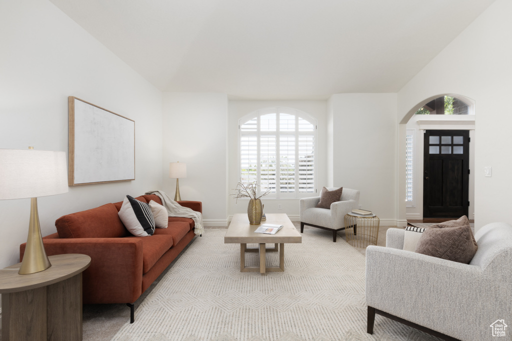 Living room with healthy amount of natural light, arched walkways, and baseboards