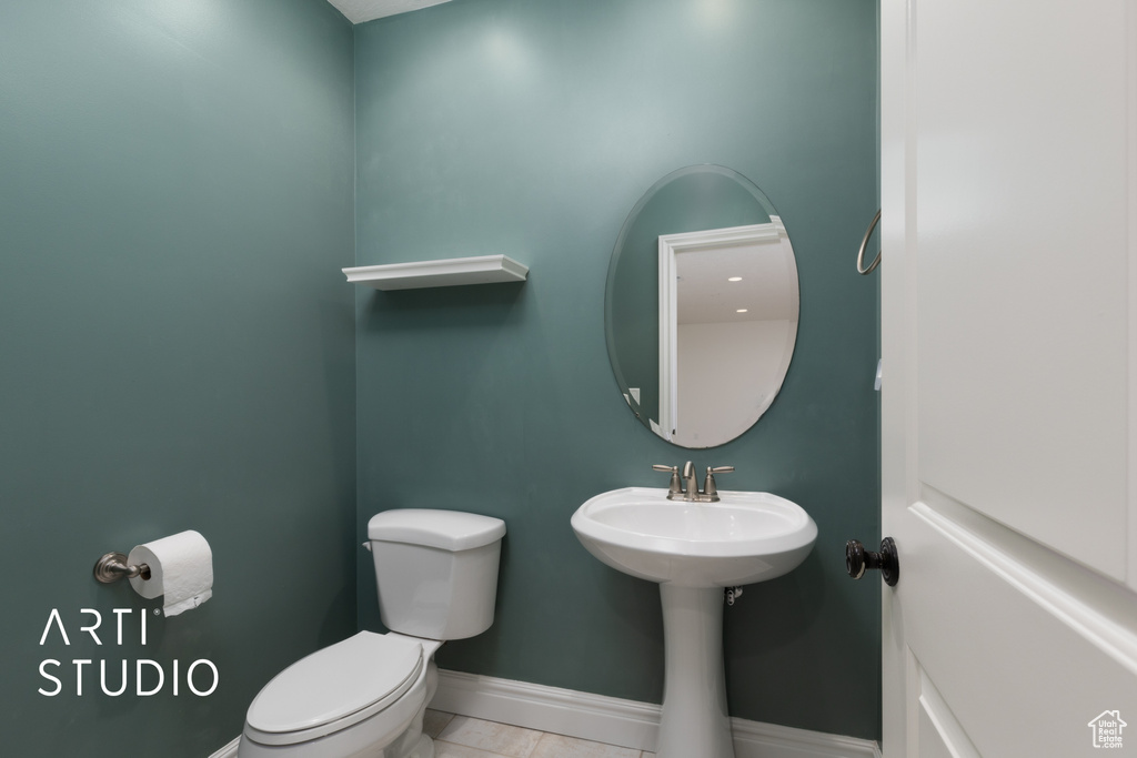 Bathroom with toilet, baseboards, and tile patterned flooring