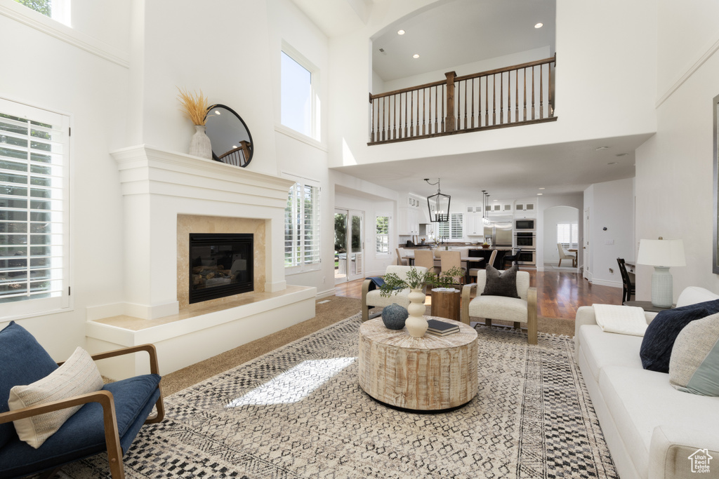 Living room with a high ceiling, a premium fireplace, recessed lighting, and baseboards