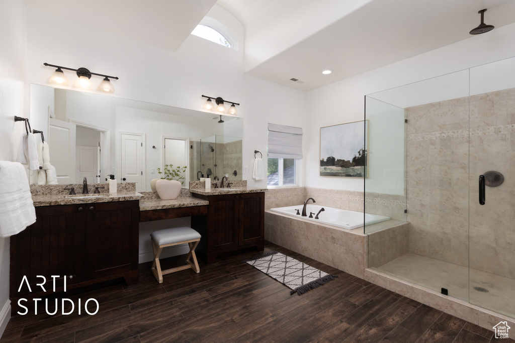 Bathroom with a stall shower, a garden tub, wood finished floors, and vanity