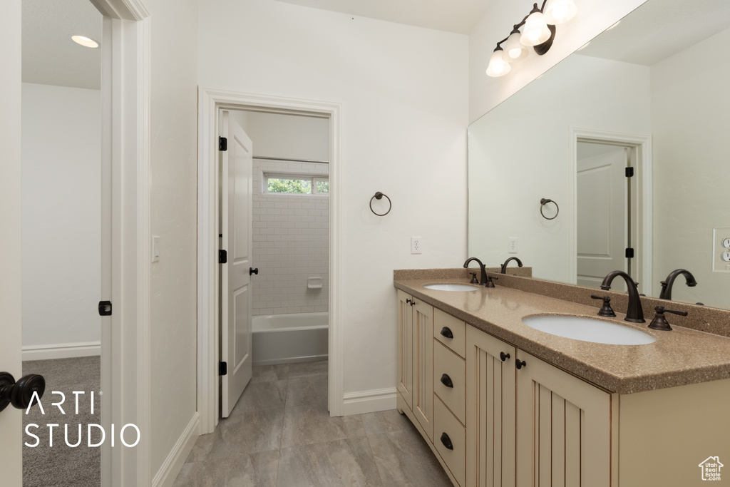 Full bathroom featuring baseboards and double vanity