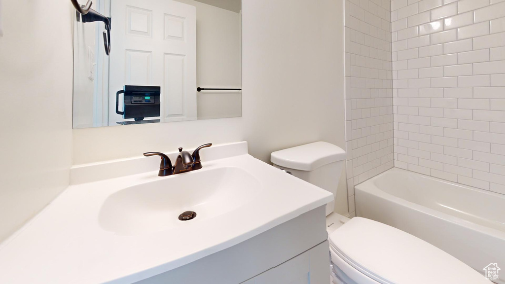 Bathroom featuring toilet, vanity, and  shower combination