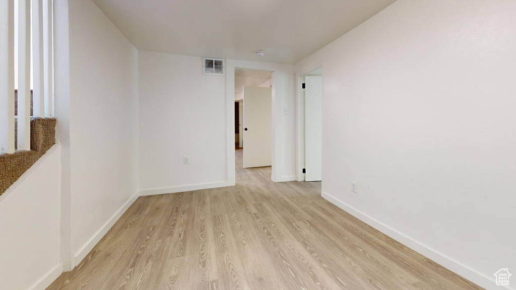 Spare room featuring light wood finished floors and baseboards