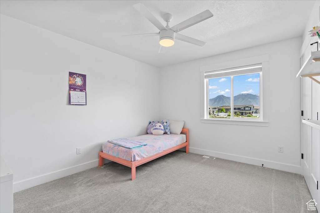 Bedroom with carpet flooring, baseboards, ceiling fan, and a mountain view