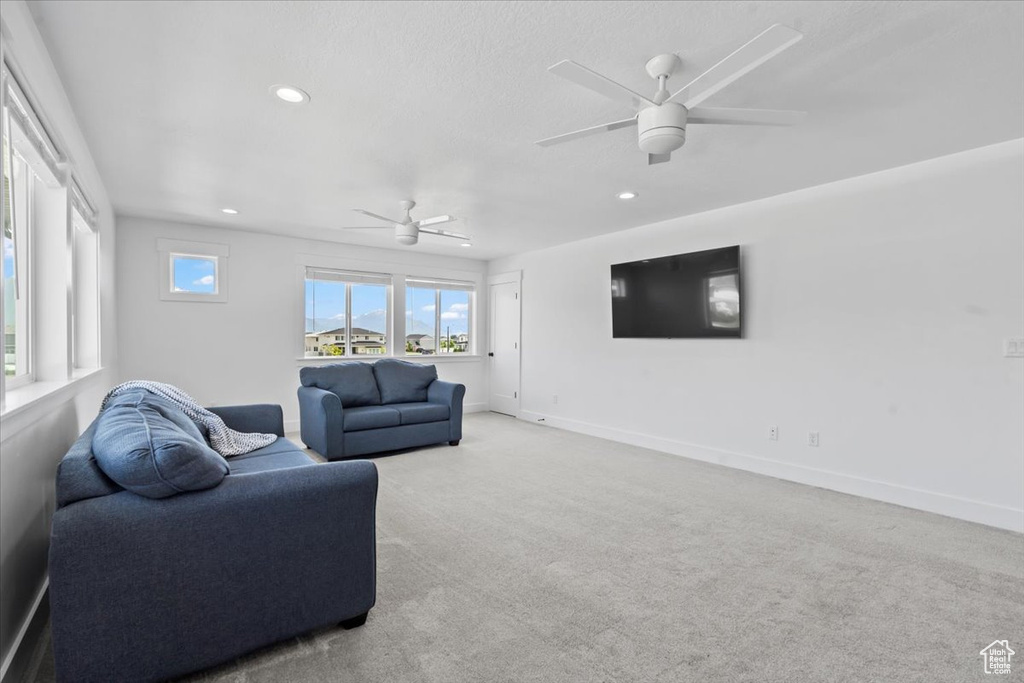 Living room featuring a ceiling fan, recessed lighting, carpet, and baseboards