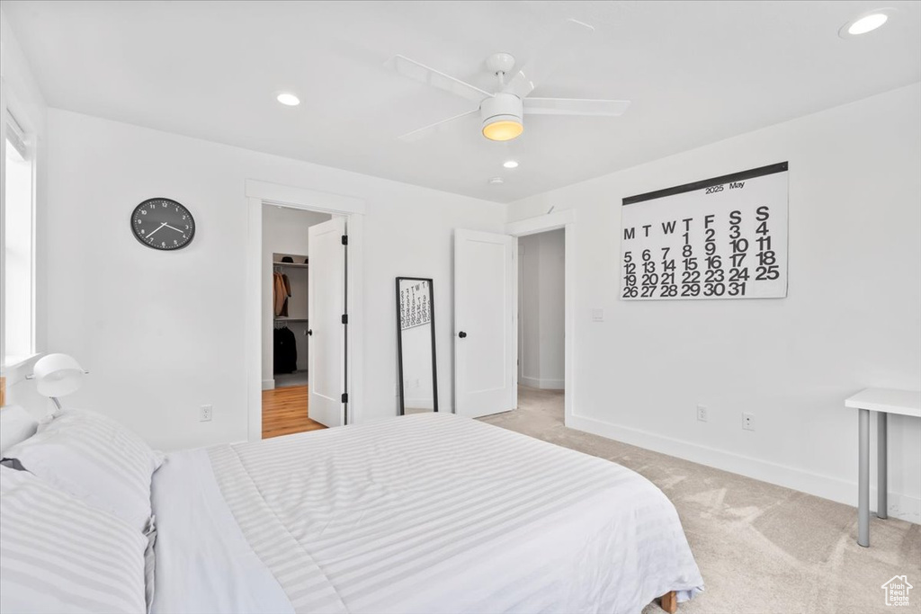 Bedroom featuring baseboards, light carpet, a spacious closet, recessed lighting, and ceiling fan