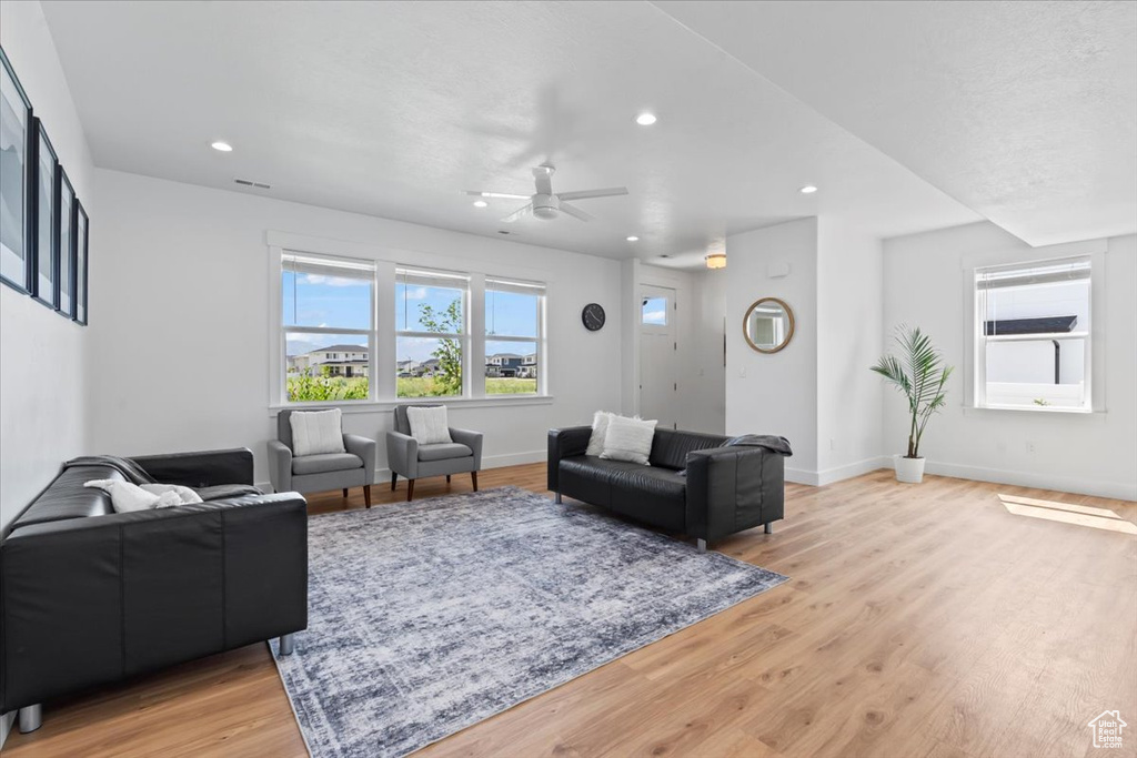 Living room featuring ceiling fan, light wood finished floors, recessed lighting, and baseboards