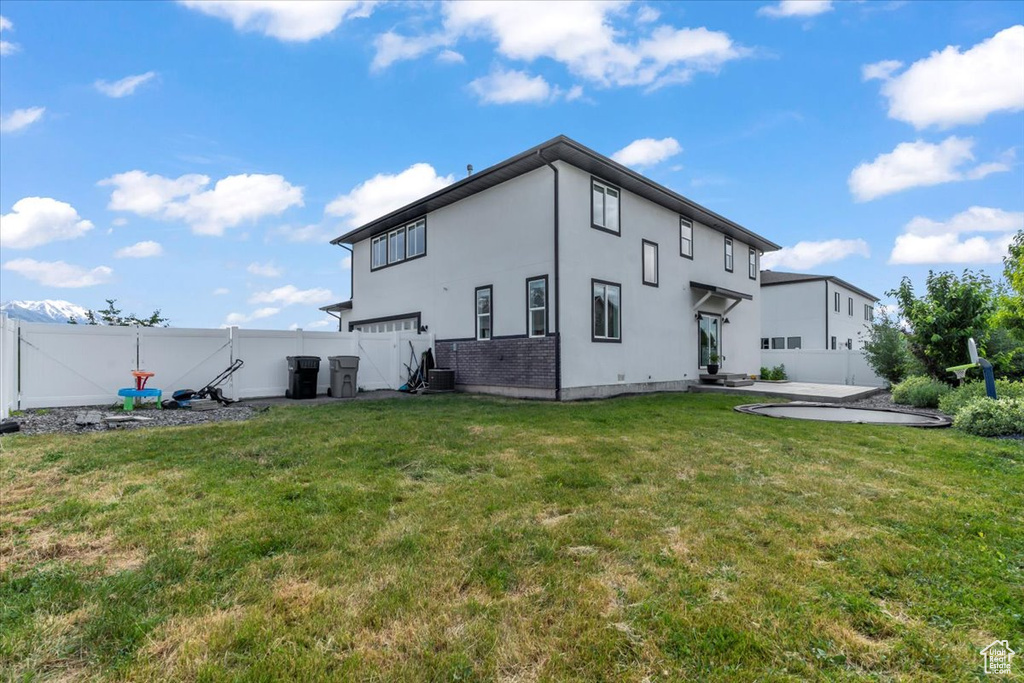 Rear view of property featuring a patio area, stucco siding, and a garage