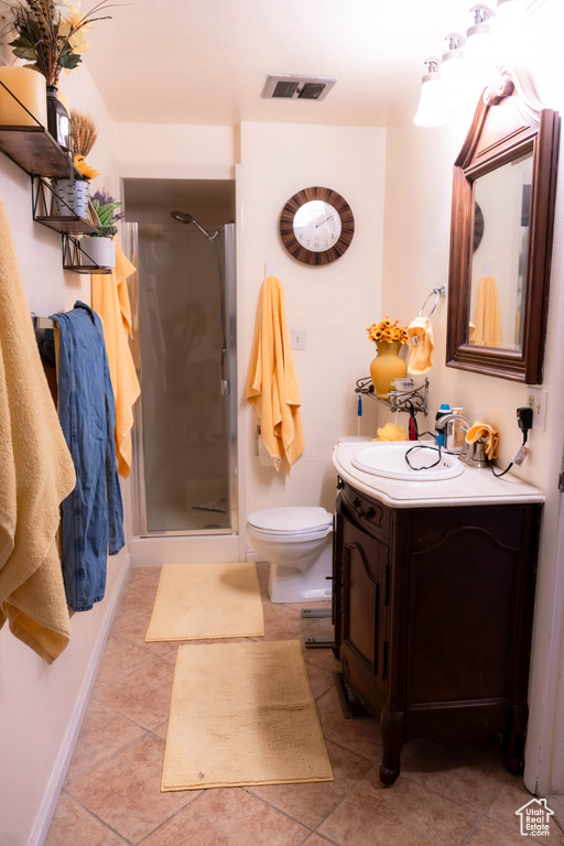 Full bathroom featuring vanity, a shower stall, toilet, tile patterned flooring, and baseboards