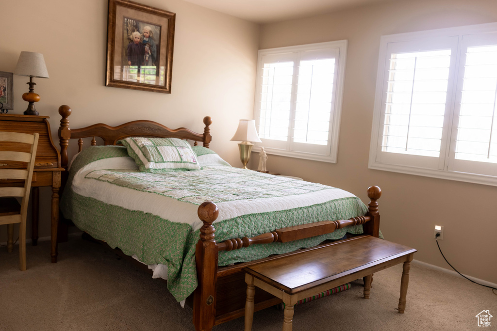 Bedroom featuring carpet and baseboards