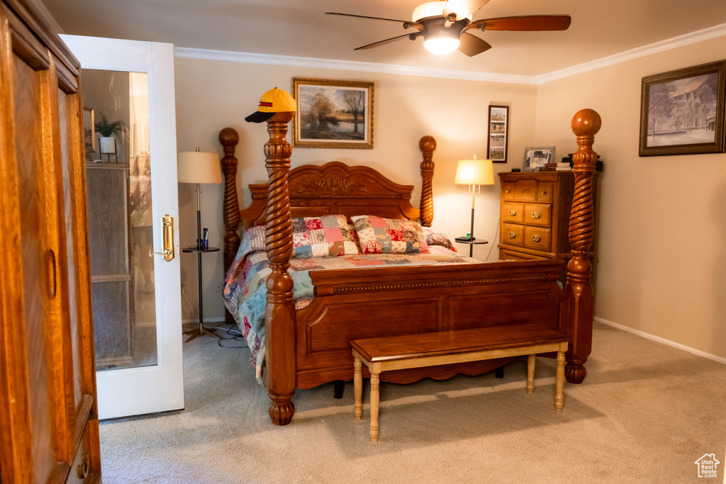 Carpeted bedroom featuring crown molding, a ceiling fan, and baseboards