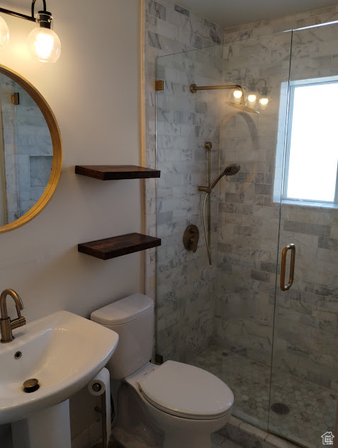 Full bath with a shower stall, toilet, and a sink