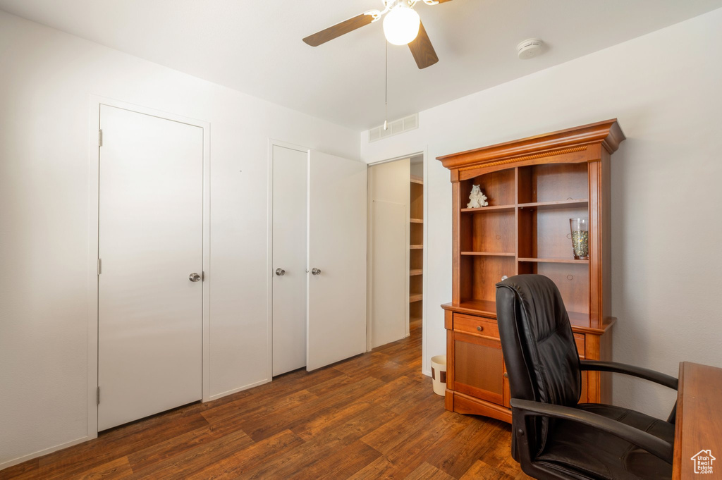 Office area featuring ceiling fan and dark wood-type flooring