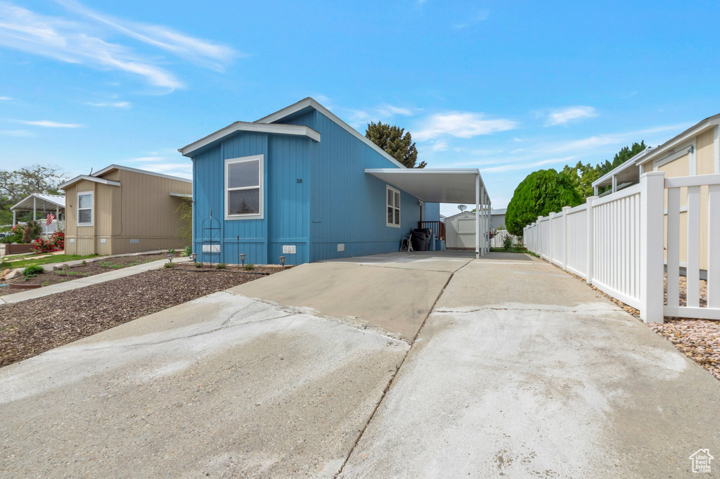 View of front of home featuring concrete driveway, a carport, and crawl space