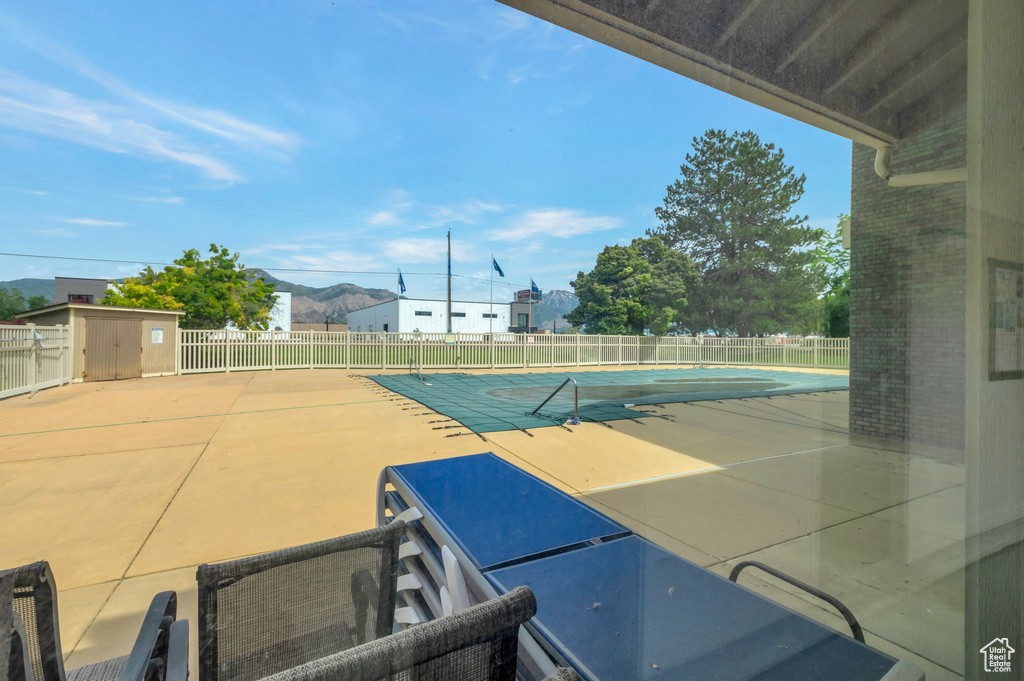 View of tennis court featuring an outdoor structure