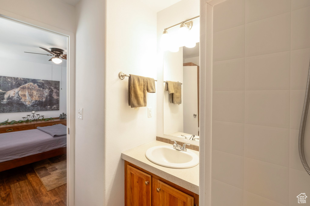 Bathroom featuring vanity, a ceiling fan, wood finished floors, and connected bathroom