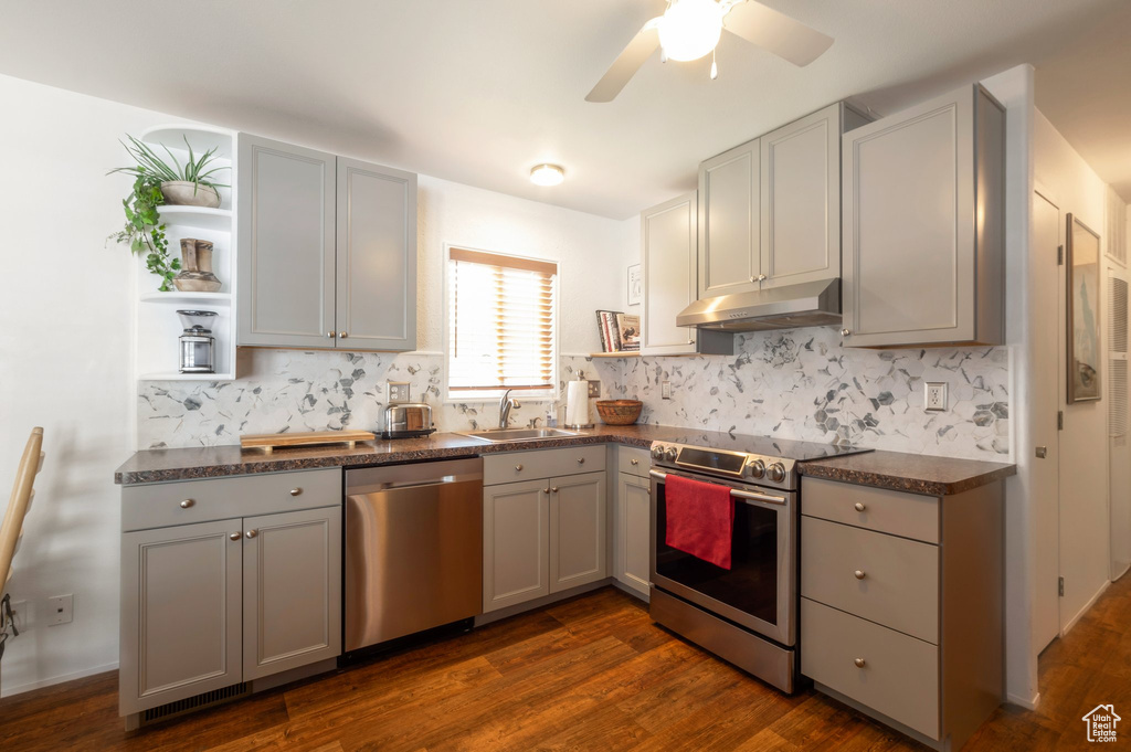Kitchen featuring stainless steel appliances, open shelves, under cabinet range hood, and gray cabinets