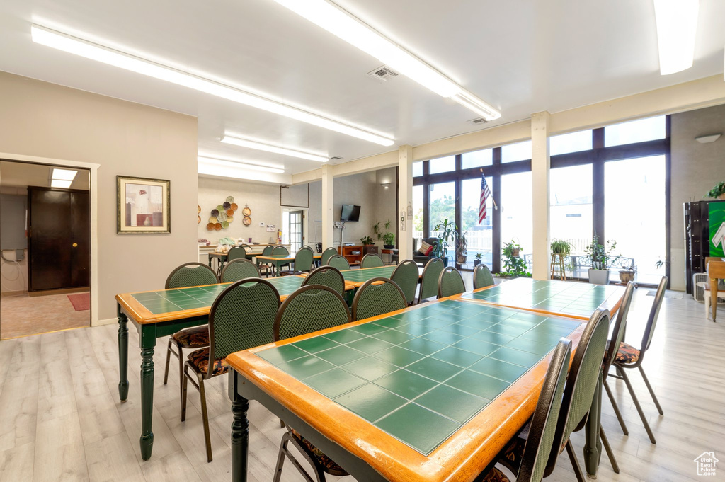 Dining area featuring light wood-type flooring and floor to ceiling windows