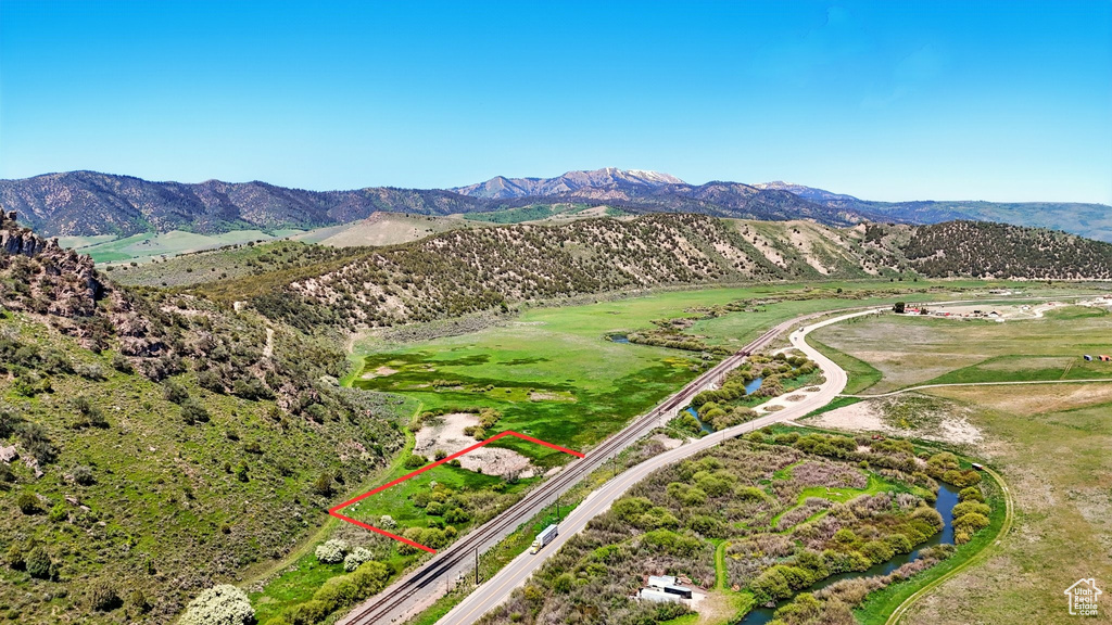Aerial view of property and surrounding area featuring a mountain backdrop and property boundaries highlighted