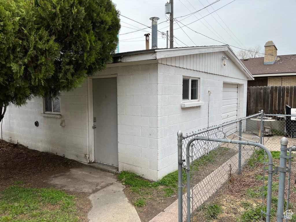 View of side of property with concrete block siding and a gate
