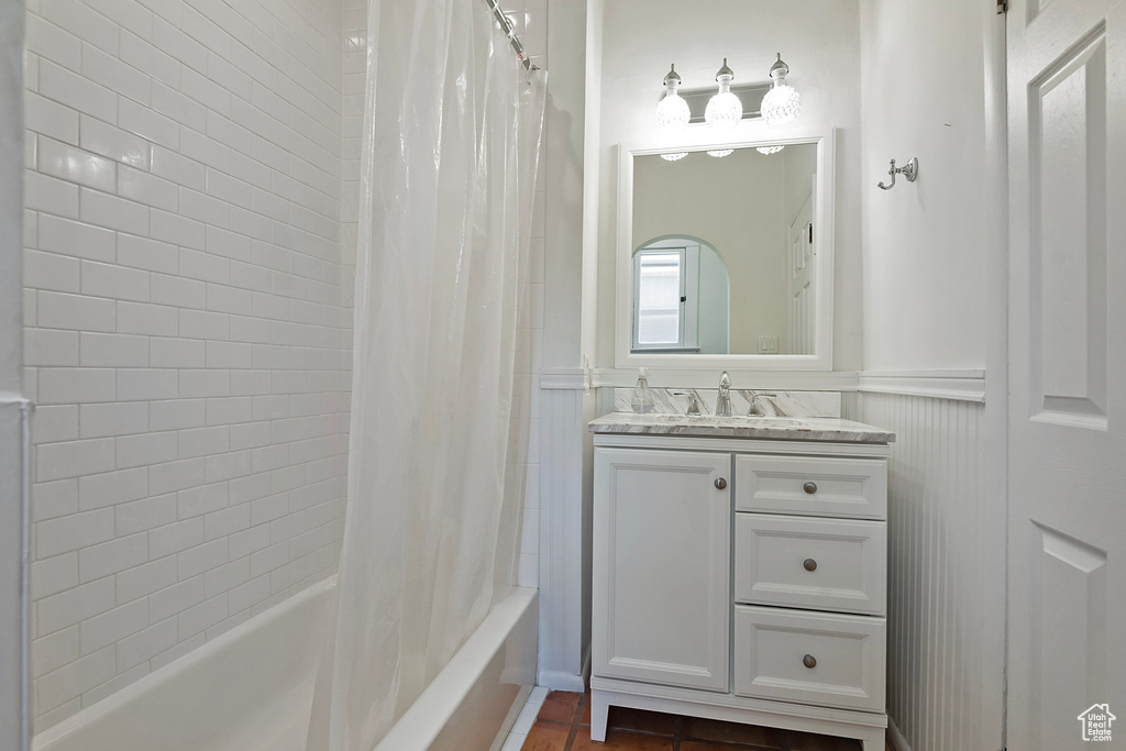 Full bathroom with vanity, shower / bathtub combination with curtain, and wainscoting