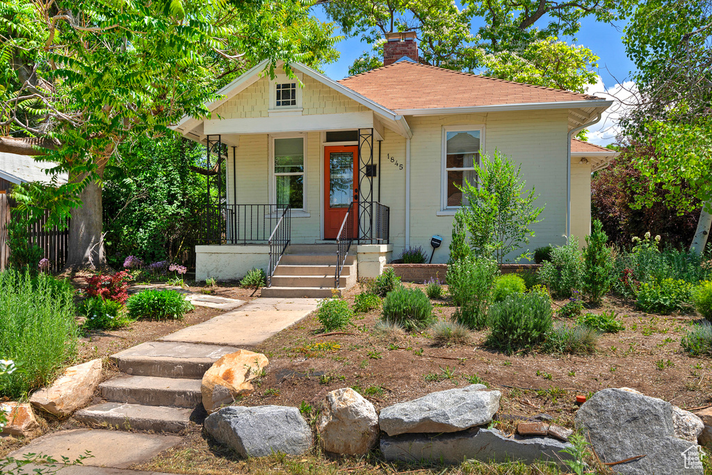 Bungalow-style home featuring covered porch and a chimney