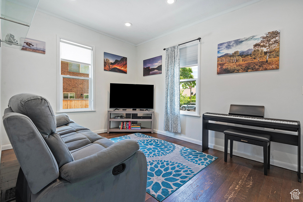 Living area with healthy amount of natural light, crown molding, hardwood / wood-style flooring, baseboards, and recessed lighting