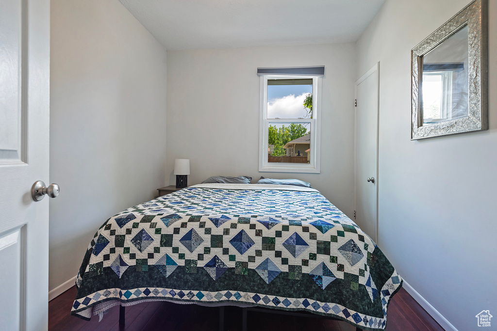 Bedroom featuring dark wood-style flooring and baseboards