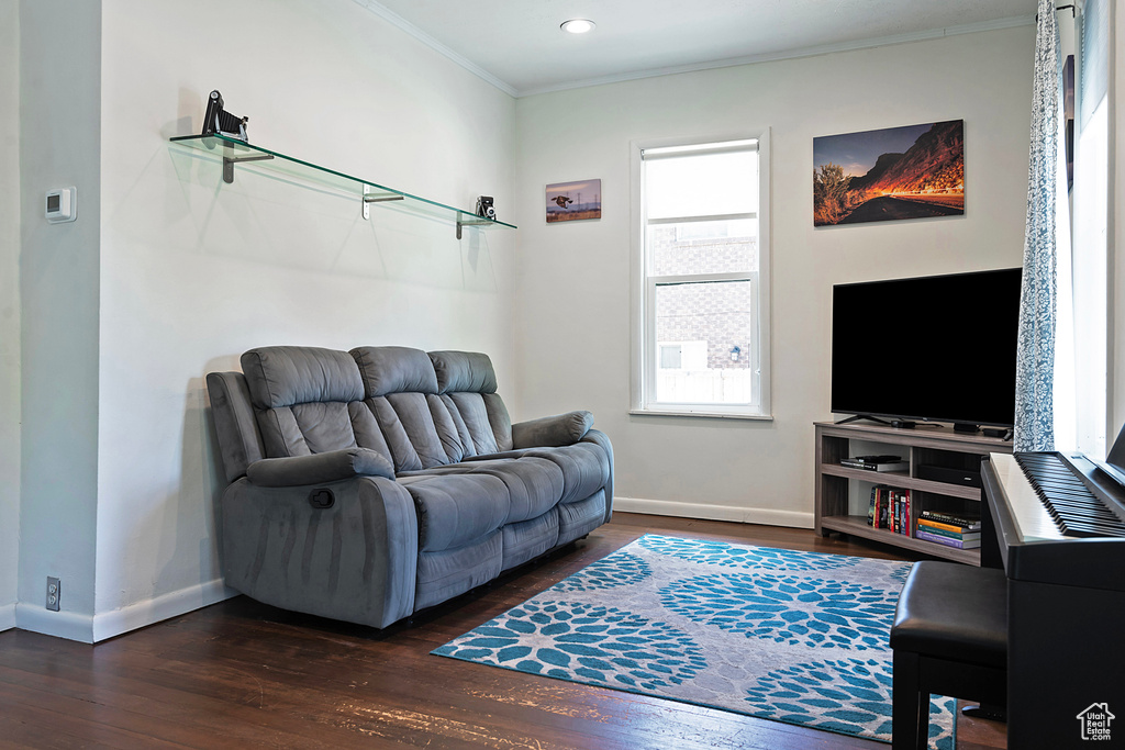 Living room with crown molding, dark wood-style floors, baseboards, and recessed lighting