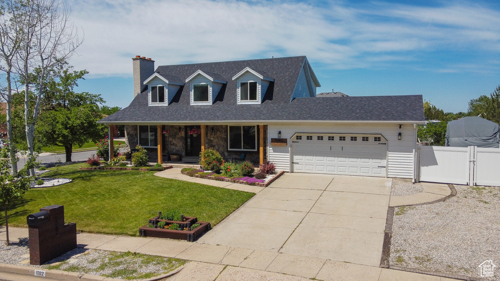 Cape cod house with a garage, a porch, a gate, a chimney, and driveway