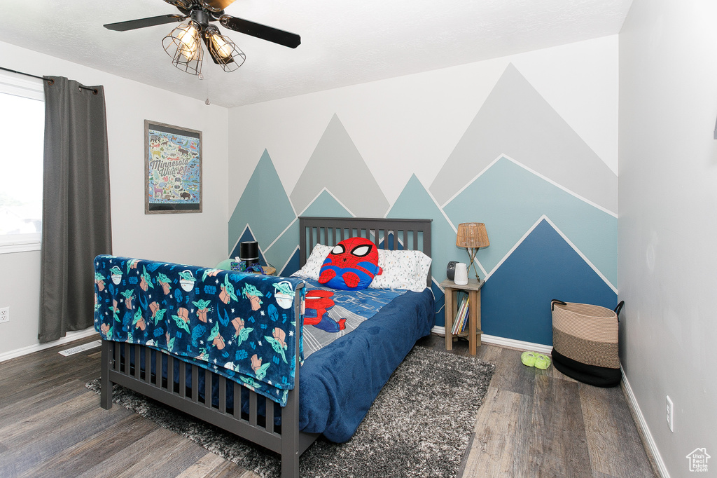 Bedroom featuring wood finished floors, baseboards, and ceiling fan
