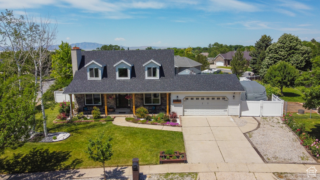Cape cod-style house featuring a gate, an attached garage, a porch, concrete driveway, and a shingled roof
