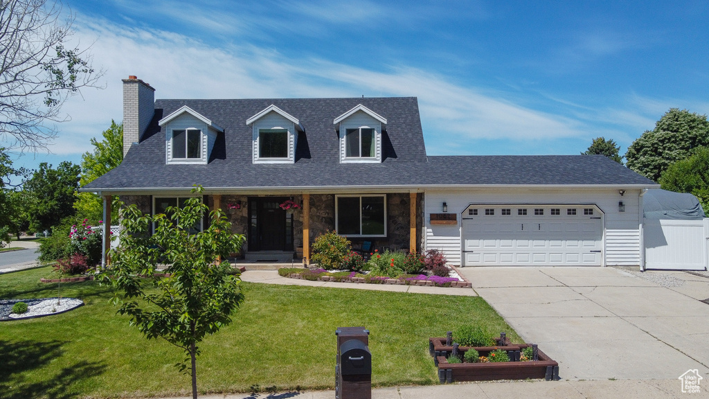 Cape cod home featuring a garage, driveway, roof with shingles, and a chimney