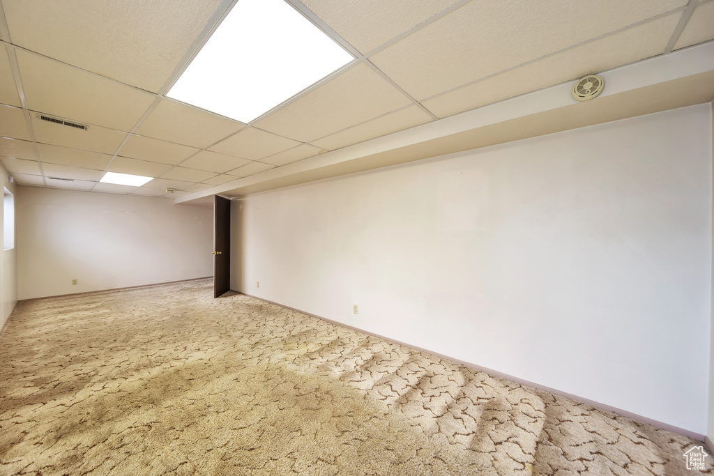Finished basement with a drop ceiling and baseboards