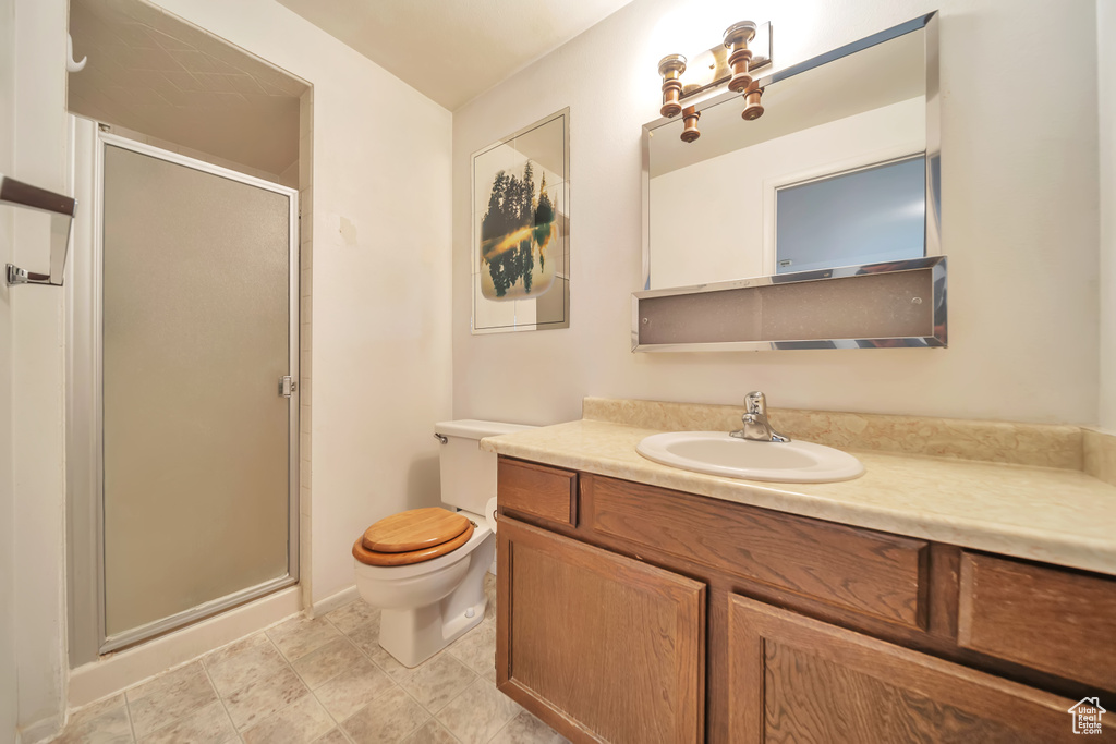 Full bathroom with vanity, a stall shower, and toilet