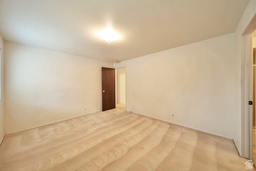Empty room featuring light carpet