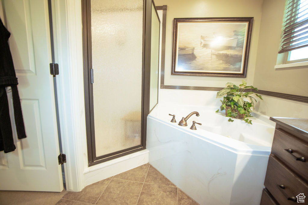 Full bath with a stall shower, tile patterned flooring, a bath, and vanity