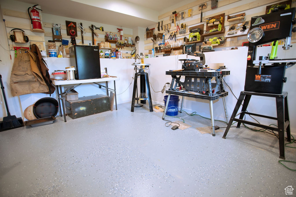 Miscellaneous room with speckle patterned floor and a workshop area