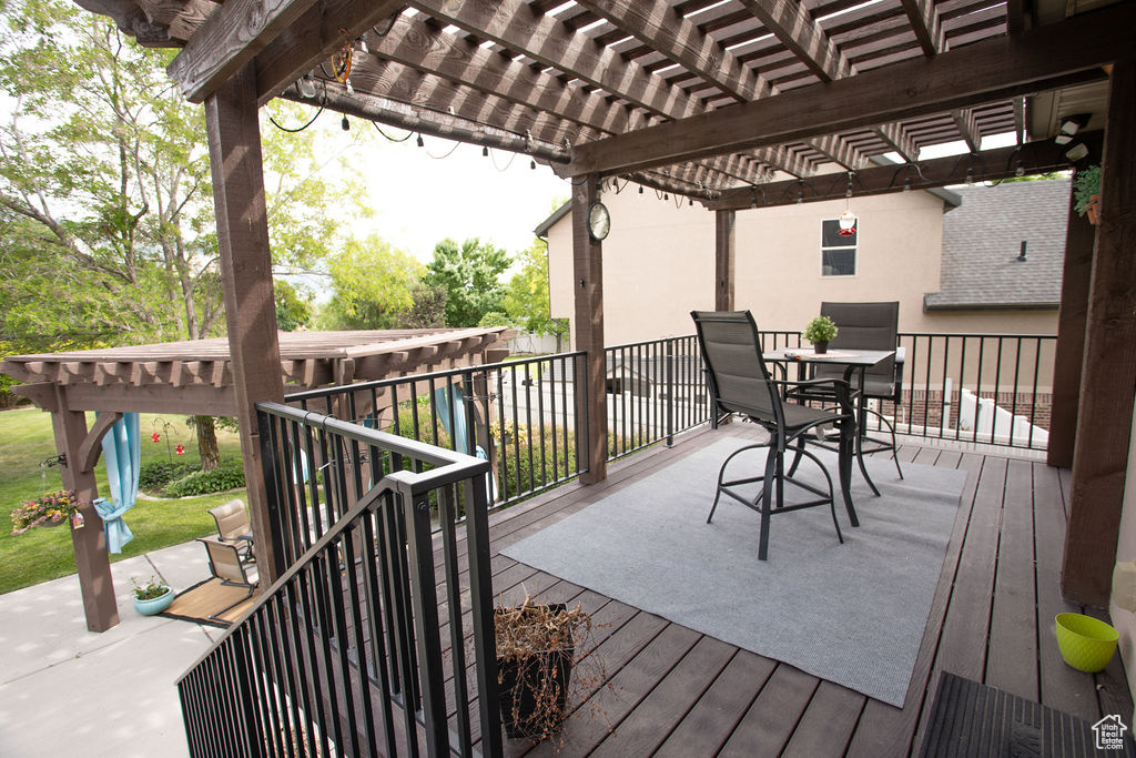 Wooden terrace with a pergola and outdoor dining space