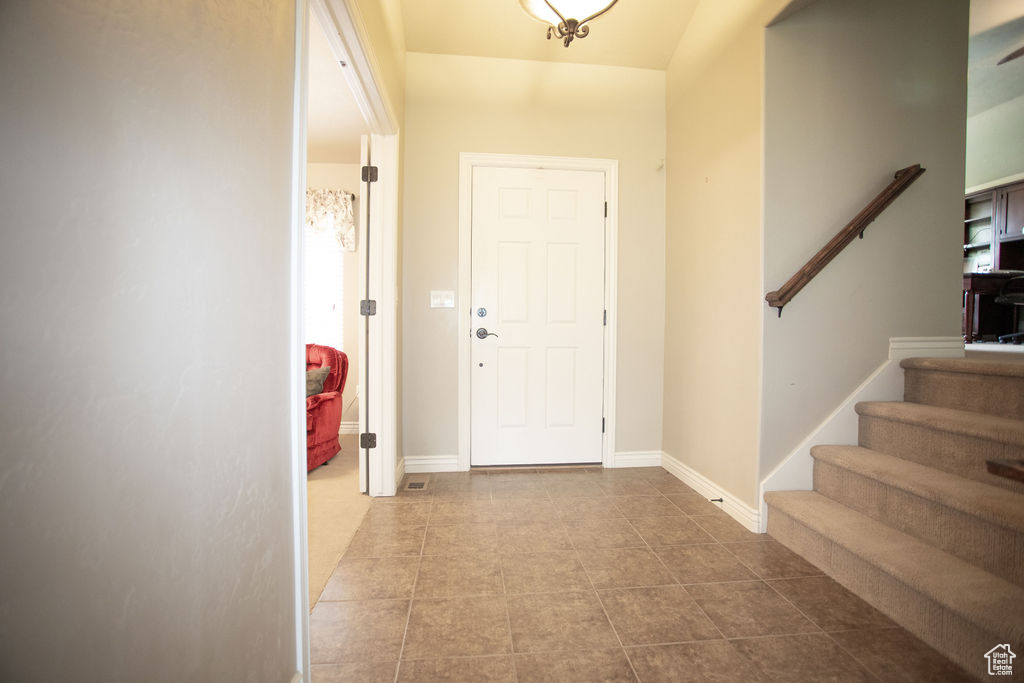 Foyer entrance featuring stairs and tile patterned floors