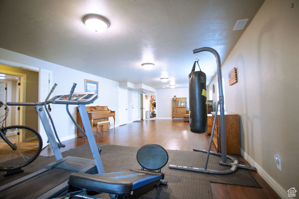 Workout area with wood finished floors and baseboards
